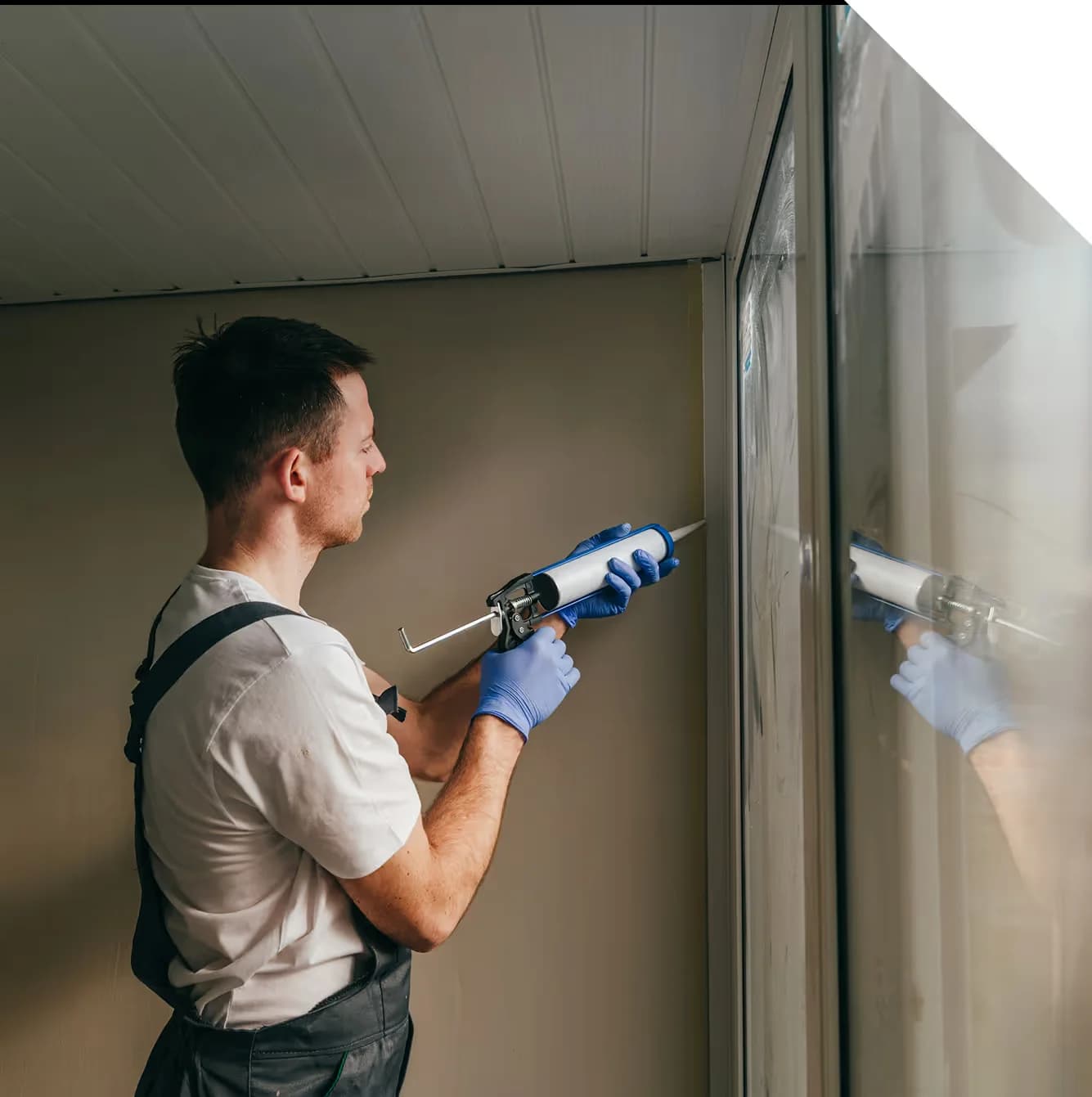 painter applying caulk to a window frame