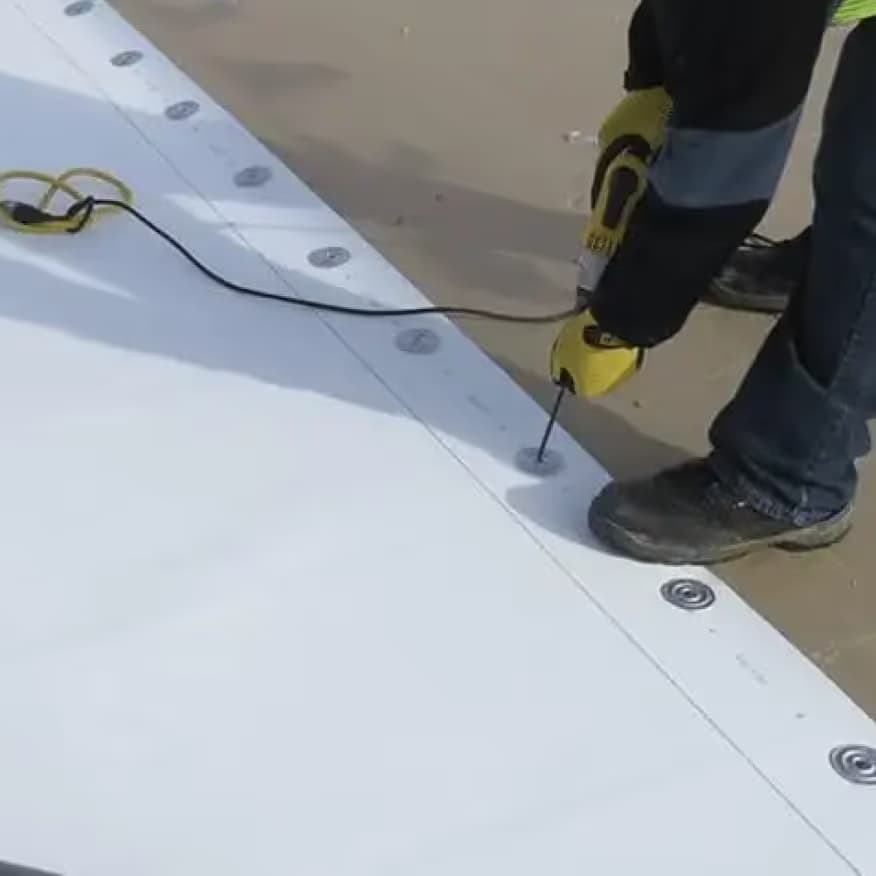 A crew welding a TPO commercial roof seam